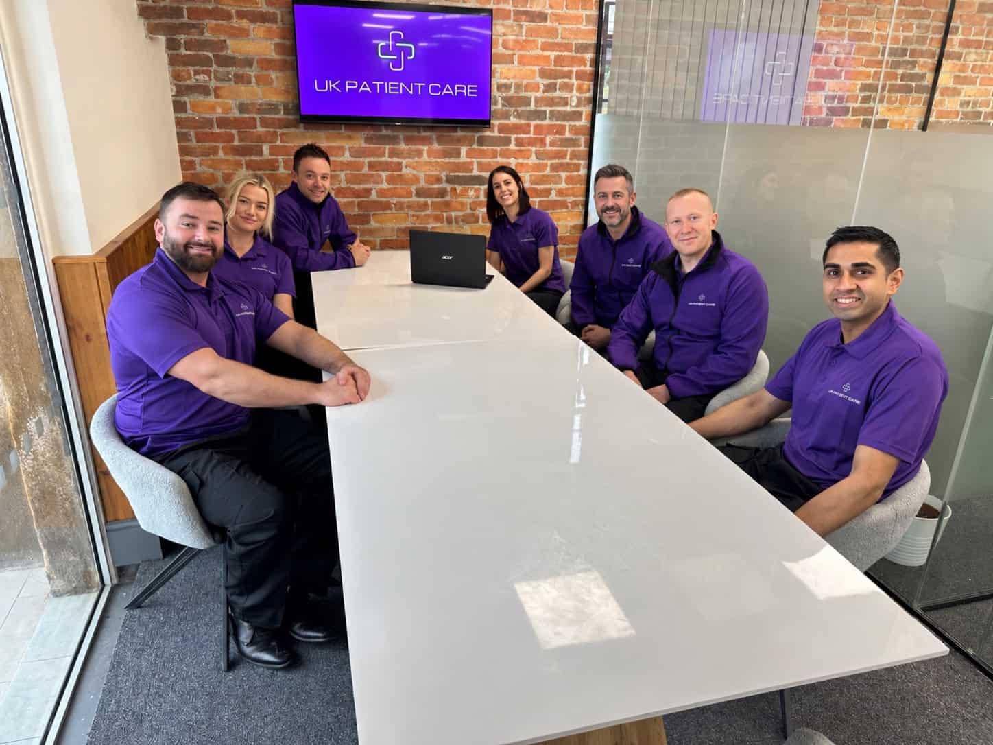 UK Patient Care Team UK Patient Care team in purple uniforms with a patient transport vehicle